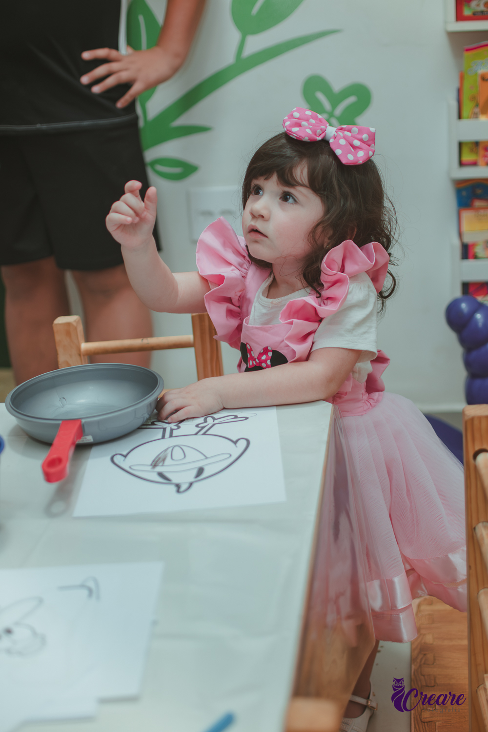 Uma menina brincando na cozinha de madeira durante sua festa de aniversário de 2 anos em São Caetano do Sul.