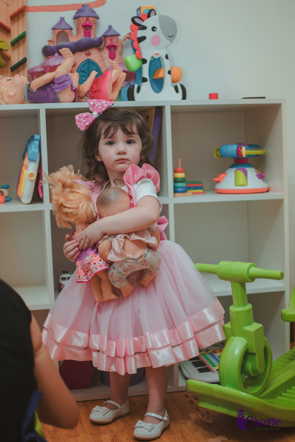 Uma menina brincando com bonecas durante sua festa de aniversário de 2 anos em São Caetano do Sul.