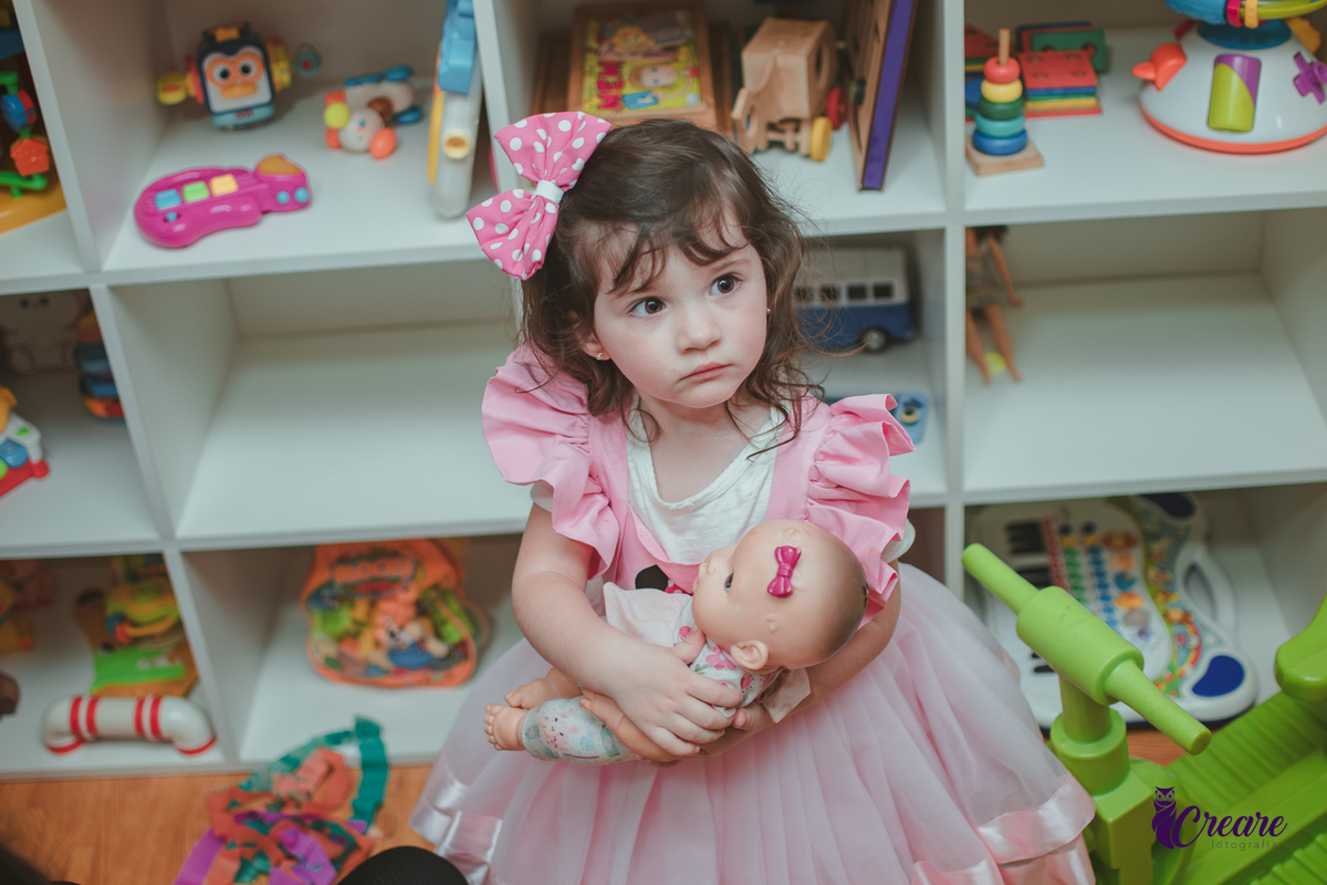 Uma menina brincando com bonecas durante sua festa de aniversário de 2 anos em São Caetano do Sul.