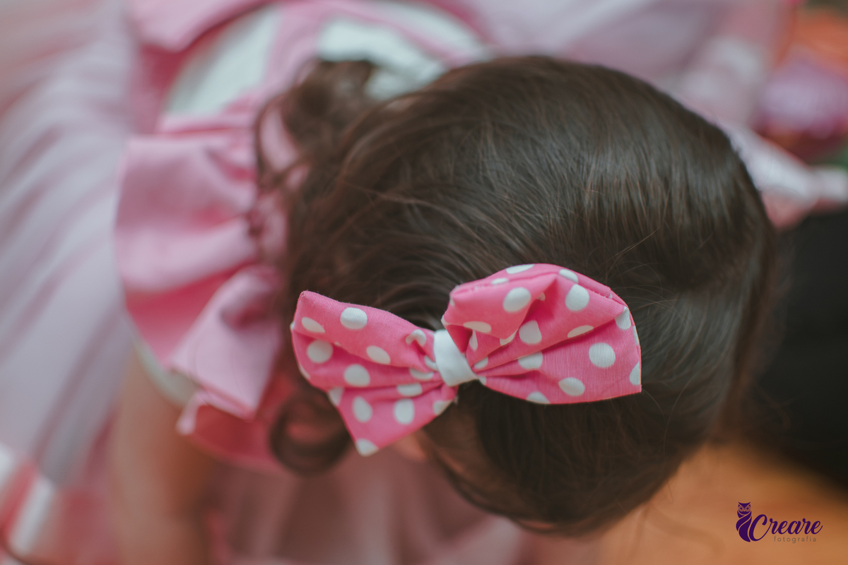 detalhes de um laço rosa na cabeça de uma menina.