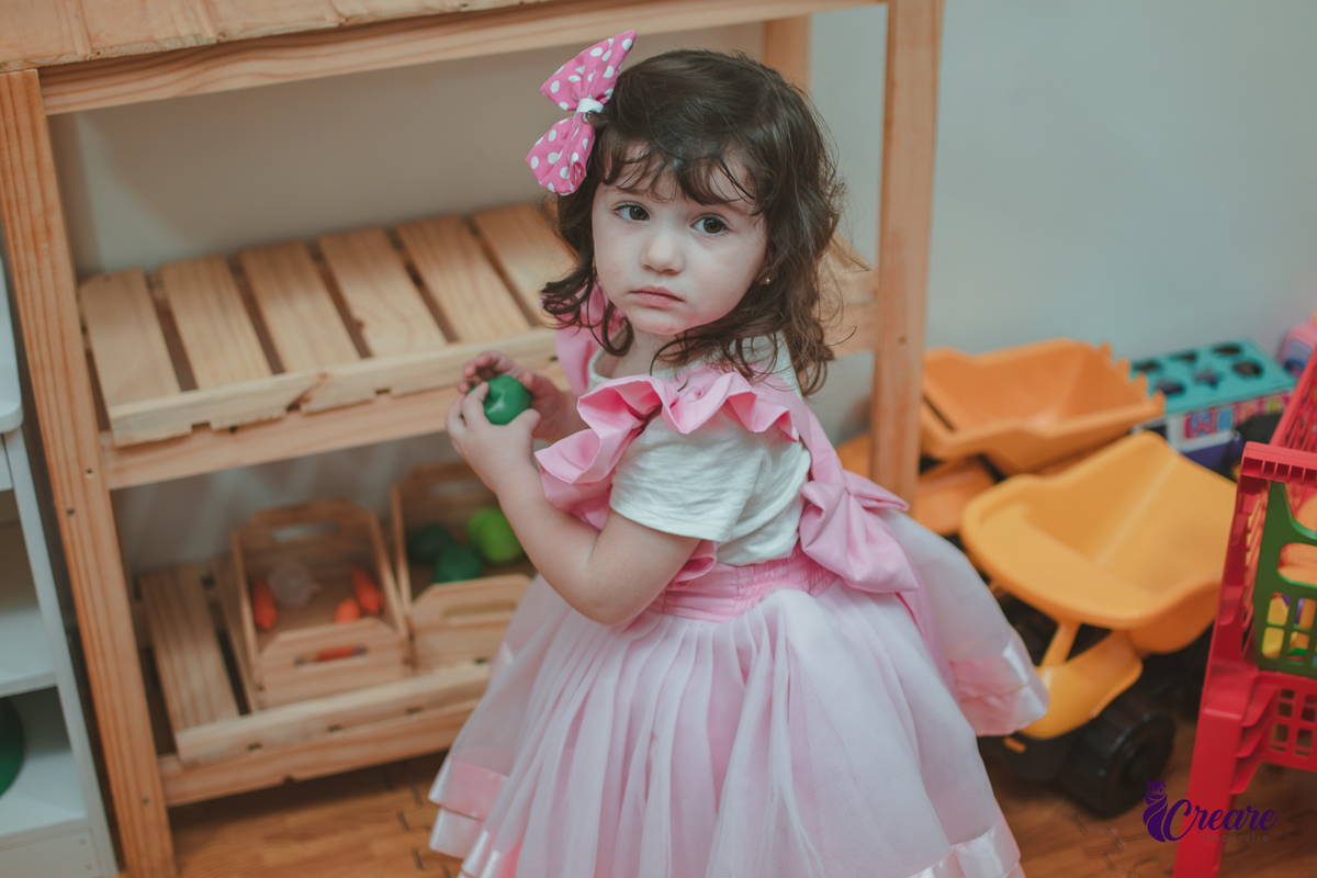 Uma menina brincando na cozinha de madeira durante sua festa de aniversário de 2 anos em São Caetano do Sul.
