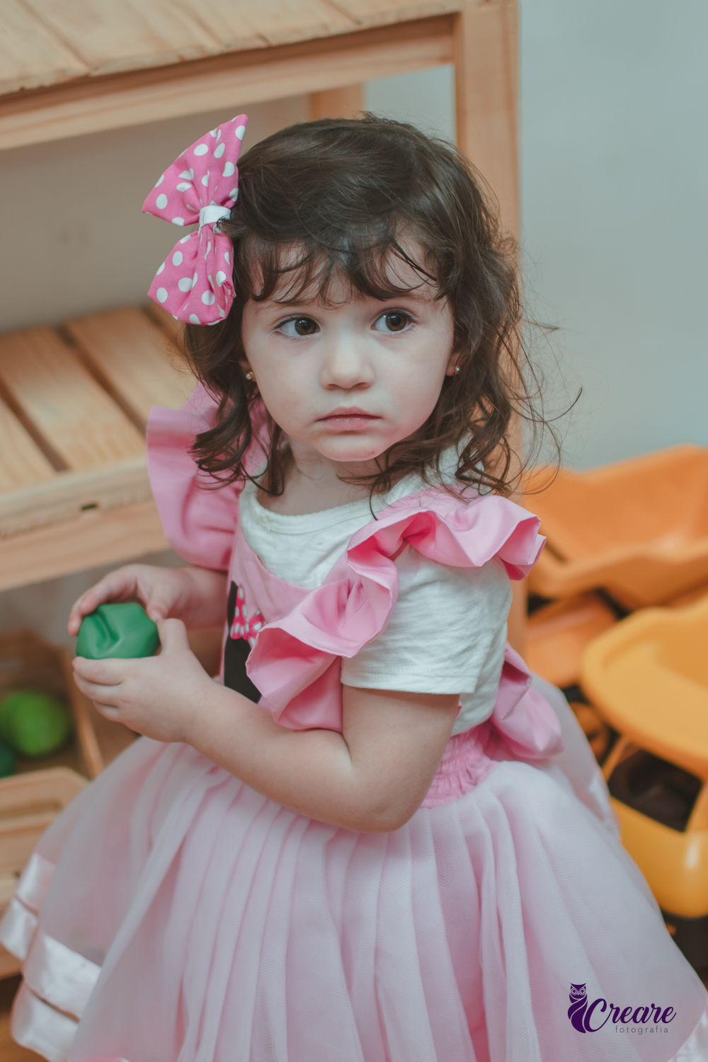 Uma menina brincando na cozinha de madeira durante sua festa de aniversário de 2 anos em São Caetano do Sul.