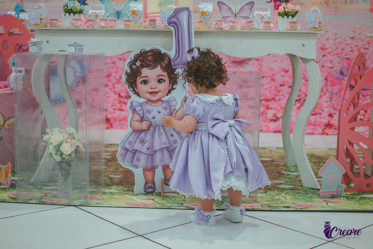 Uma menina usando vestido roxo e andando pelo salão, durante sua festa de aniversário de 1 ano no Buffet É Pique em Mauá.