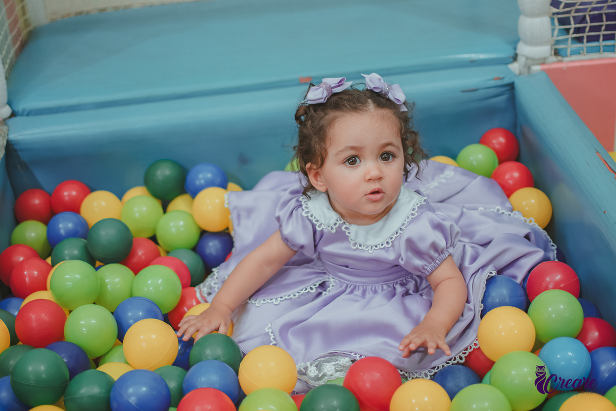 Uma bebê brincando na piscina de bolinhas, durante seu aniversário de 1 ano no Buffet É Pique em Mauá.