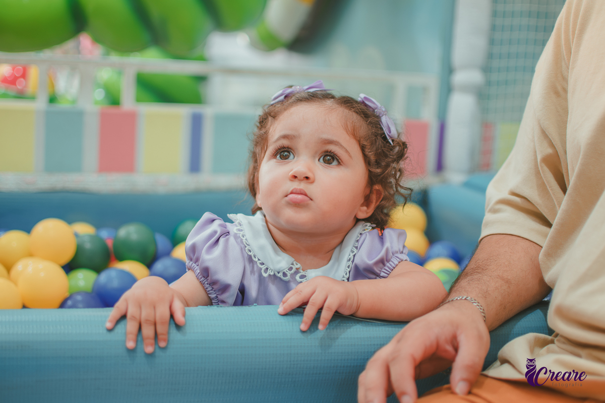 Uma bebê brincando na piscina de bolinhas, durante seu aniversário de 1 ano no Buffet É Pique em Mauá.