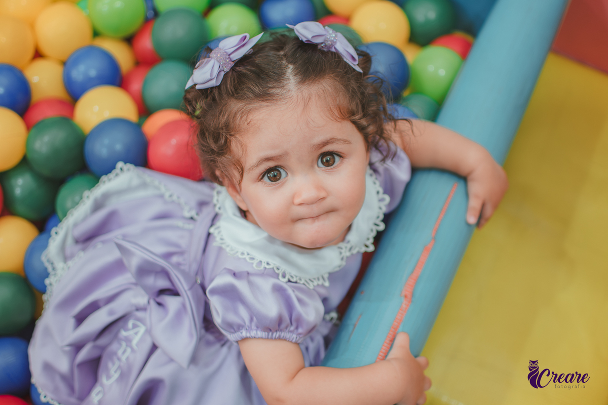 Uma bebê brincando na piscina de bolinhas, durante seu aniversário de 1 ano no Buffet É Pique em Mauá.