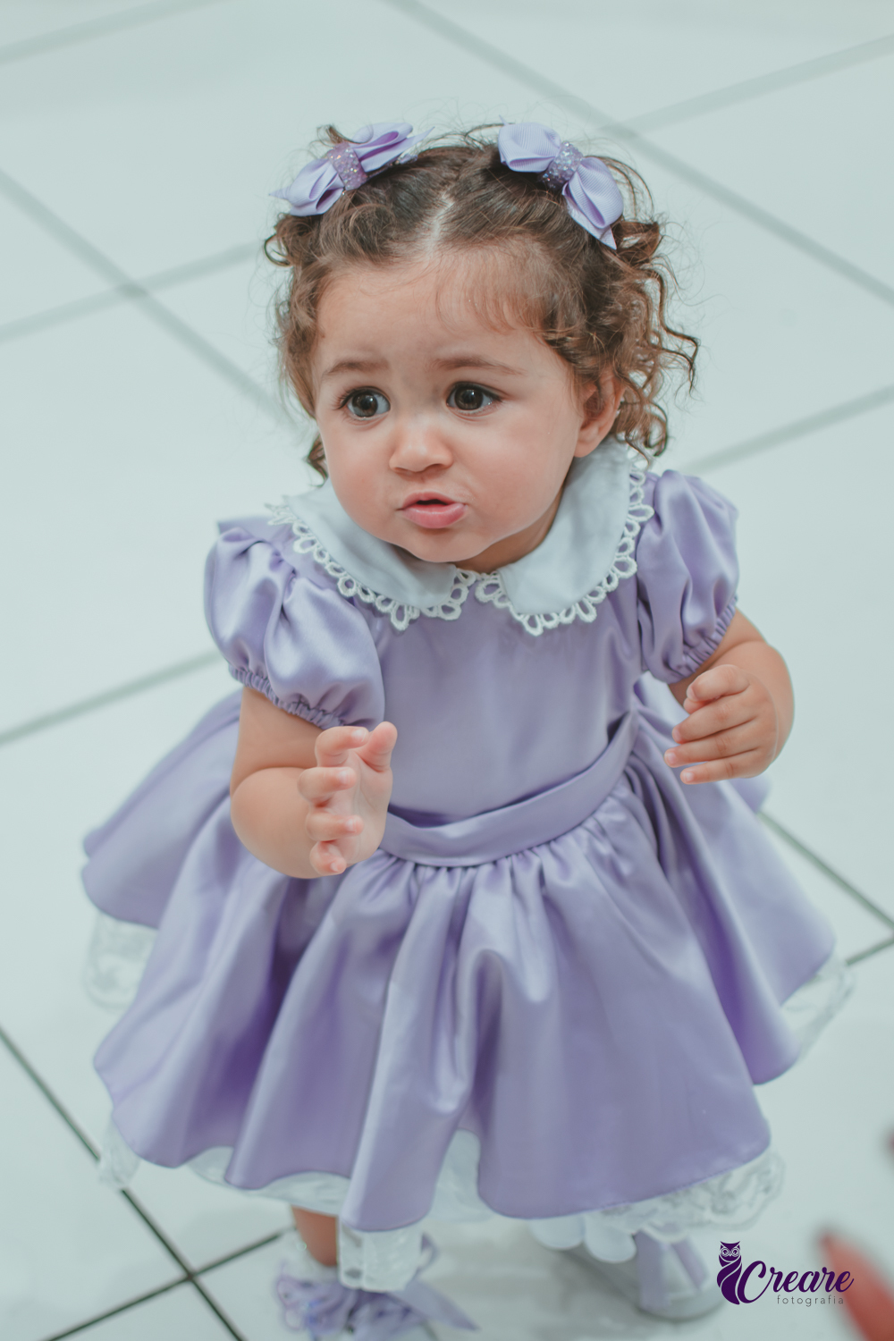 Uma menina usando vestido roxo e andando pelo salão, durante sua festa de aniversário de 1 ano no Buffet É Pique em Mauá.