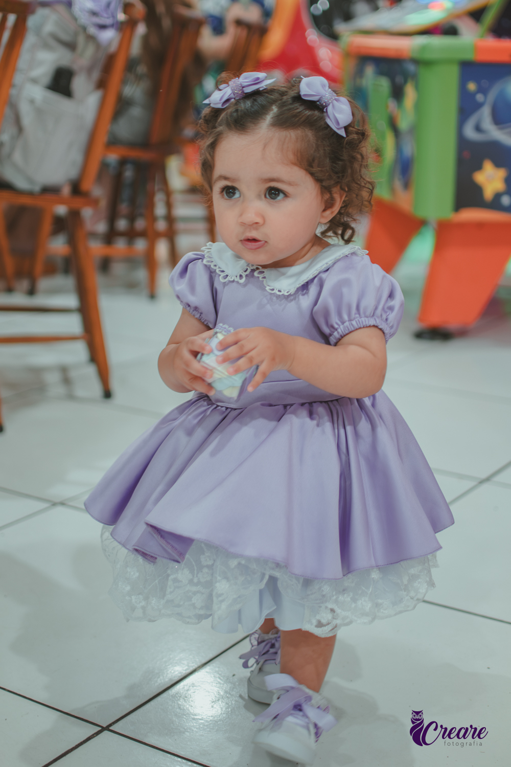 Uma menina usando vestido roxo e andando pelo salão, durante sua festa de aniversário de 1 ano no Buffet É Pique em Mauá.