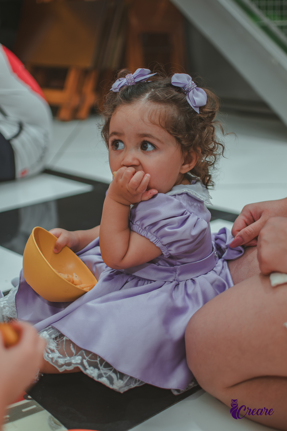 Uma bebê comendo, durante hora do lancinho no buffet é Pique.