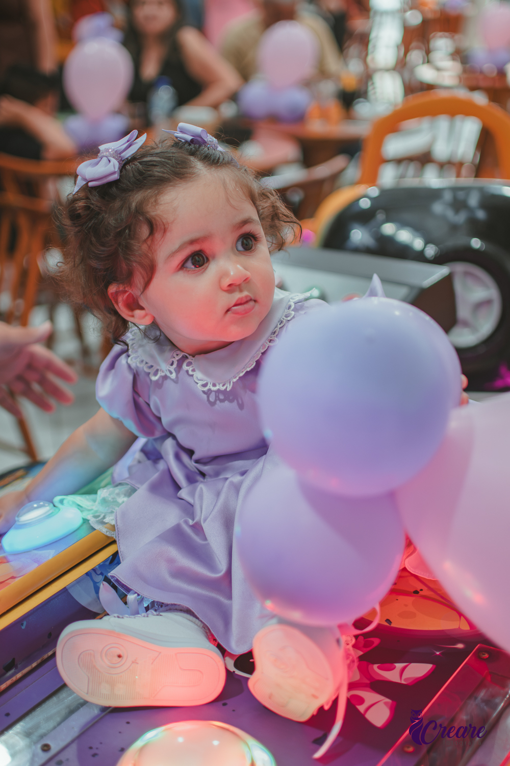 Uma bebê brincando durante sua festa de anievrsário de 1 ano.