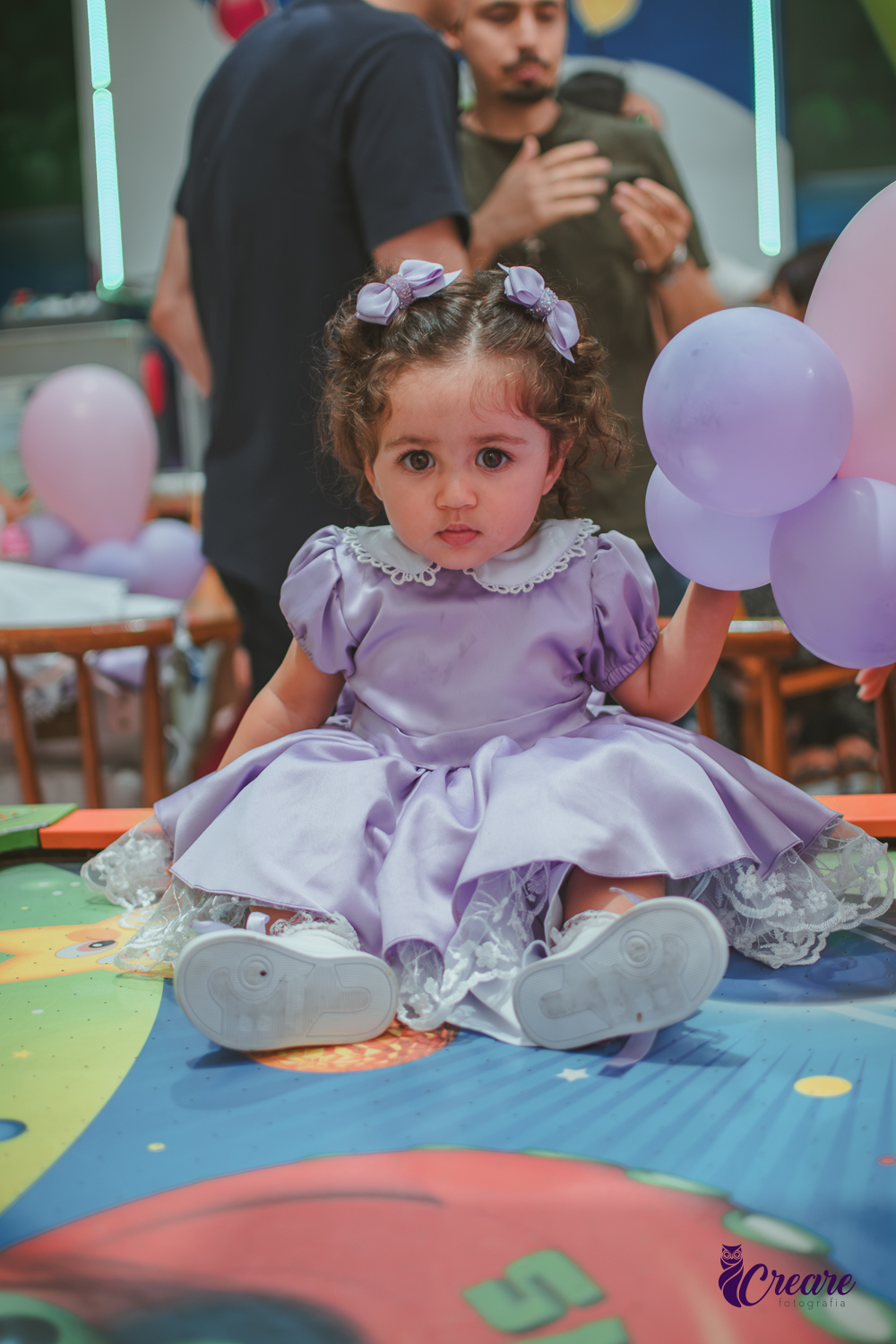 Uma bebê brincando durante sua festa de anievrsário de 1 ano.