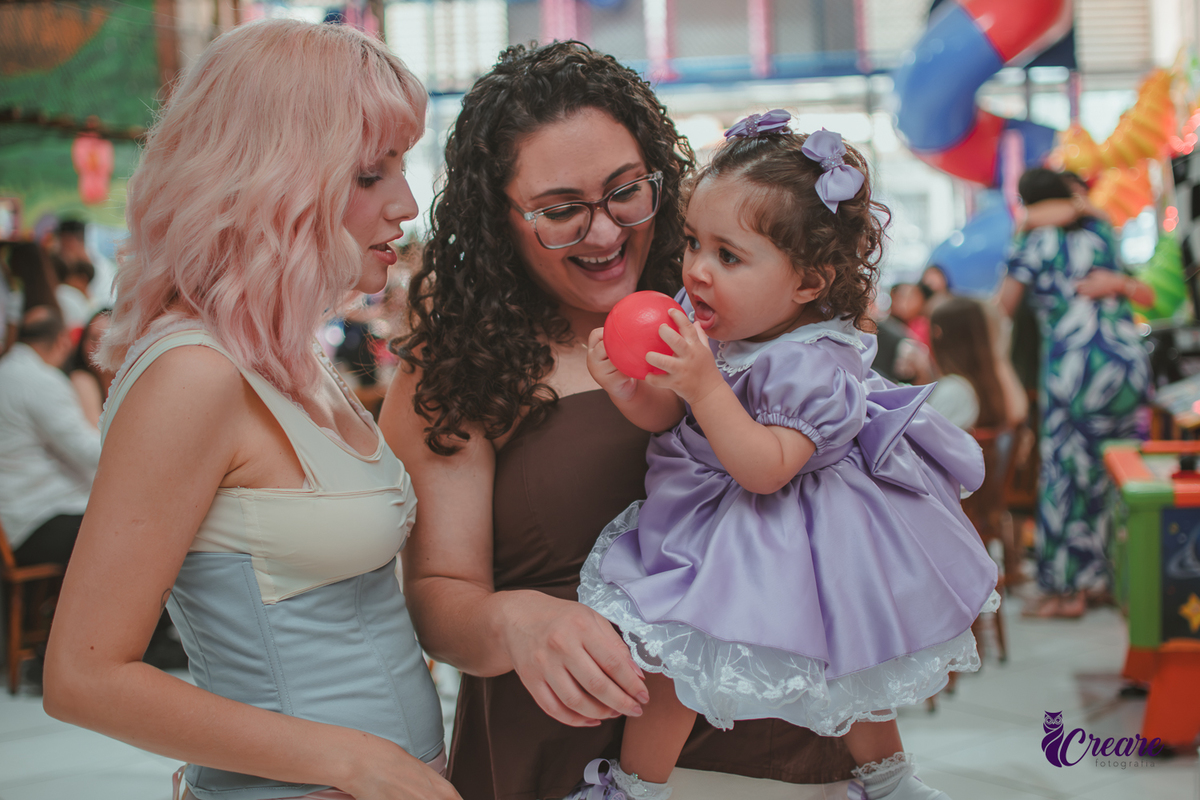 duas mulheres, brincando com bebe, durante festa de aniversário de 1 ano.