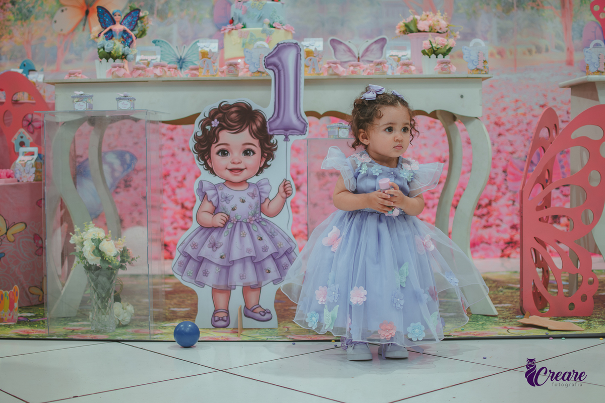 Uma menina usando vestido roxo e andando pelo salão, durante sua festa de aniversário de 1 ano no Buffet É Pique em Mauá.