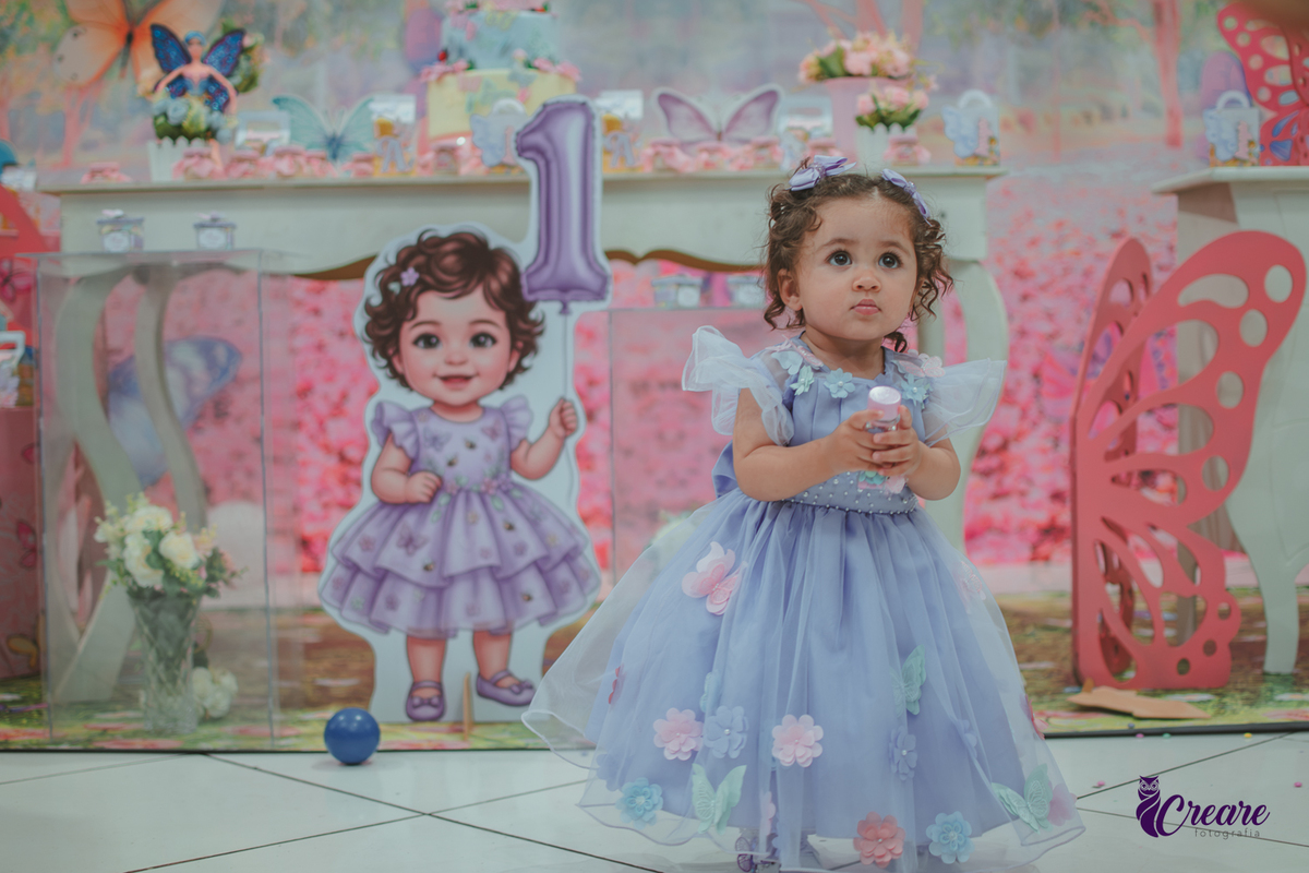 Uma menina usando vestido roxo e andando pelo salão, durante sua festa de aniversário de 1 ano no Buffet É Pique em Mauá.