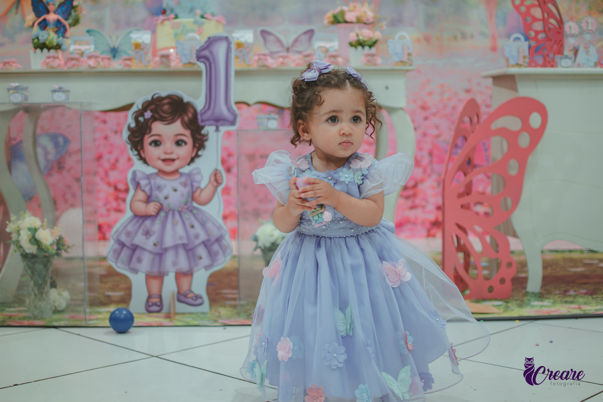 Uma menina usando vestido roxo e andando pelo salão, durante sua festa de aniversário de 1 ano no Buffet É Pique em Mauá.