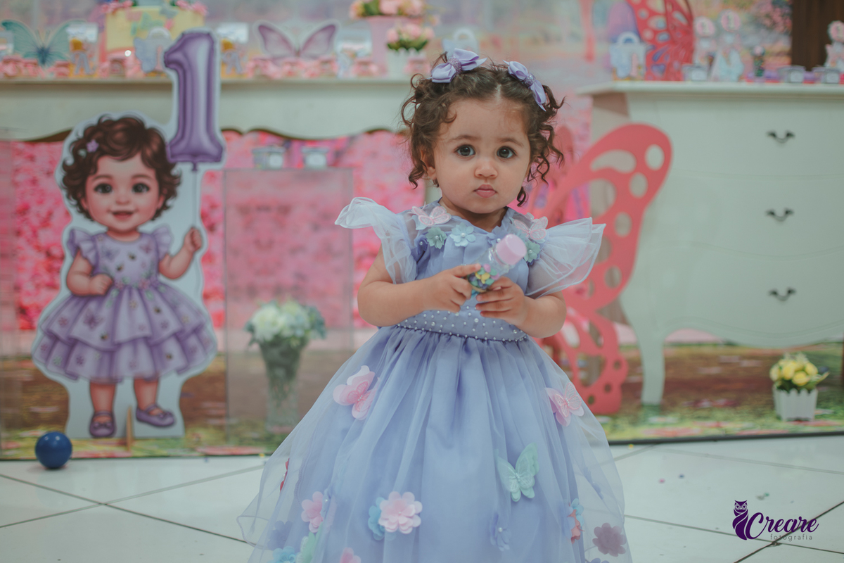 Uma menina usando vestido roxo e andando pelo salão, durante sua festa de aniversário de 1 ano no Buffet É Pique em Mauá.