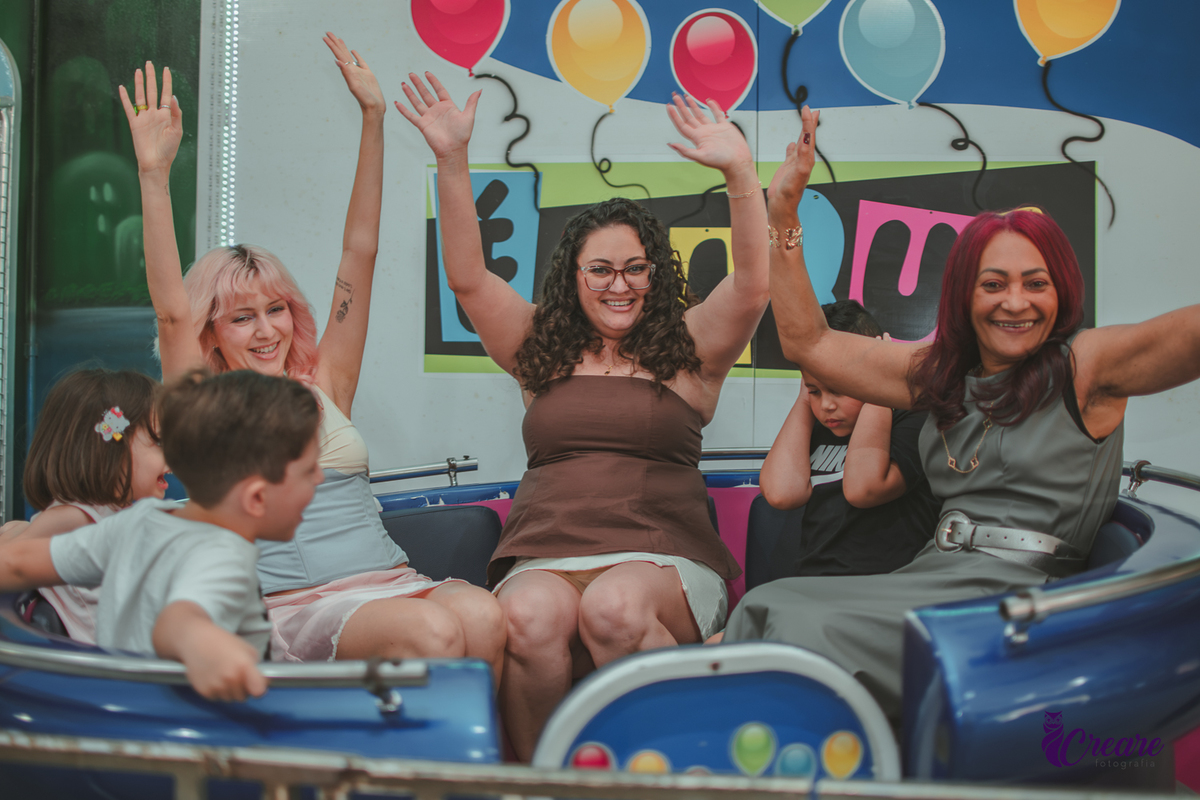 3 mulheres e 2 crianças no brinquedo de girar do Buffet é  Pique, durante festa de aniversário de 1 ano.