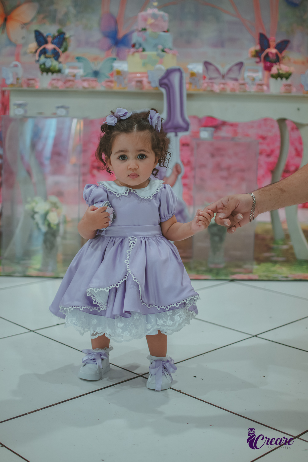 Uma menina usando vestido roxo e andando pelo salão, durante sua festa de aniversário de 1 ano no Buffet É Pique em Mauá.