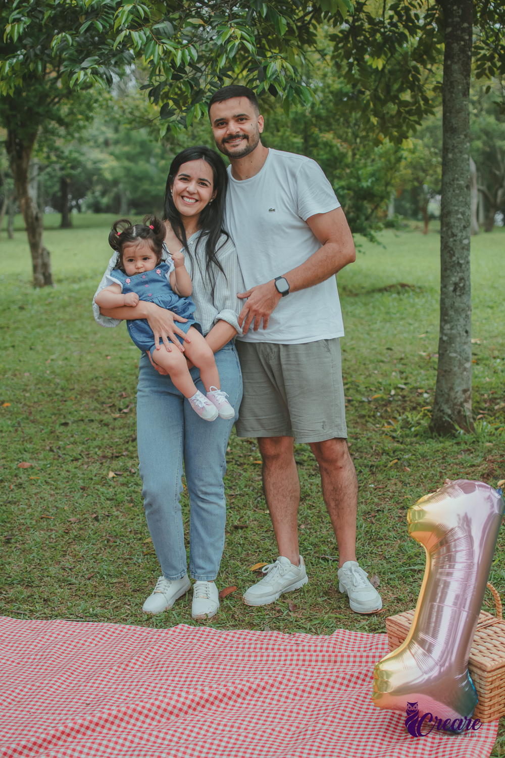 Um casal com uma bebê no colo, durante festa de aniversário de 1 ano no Parque Central de Santo André.