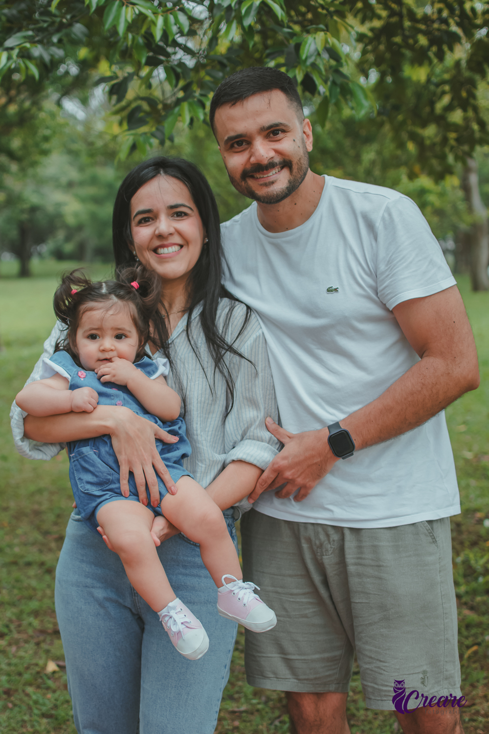 Um casal com uma bebê no colo, durante festa de aniversário de 1 ano no Parque Central de Santo André.