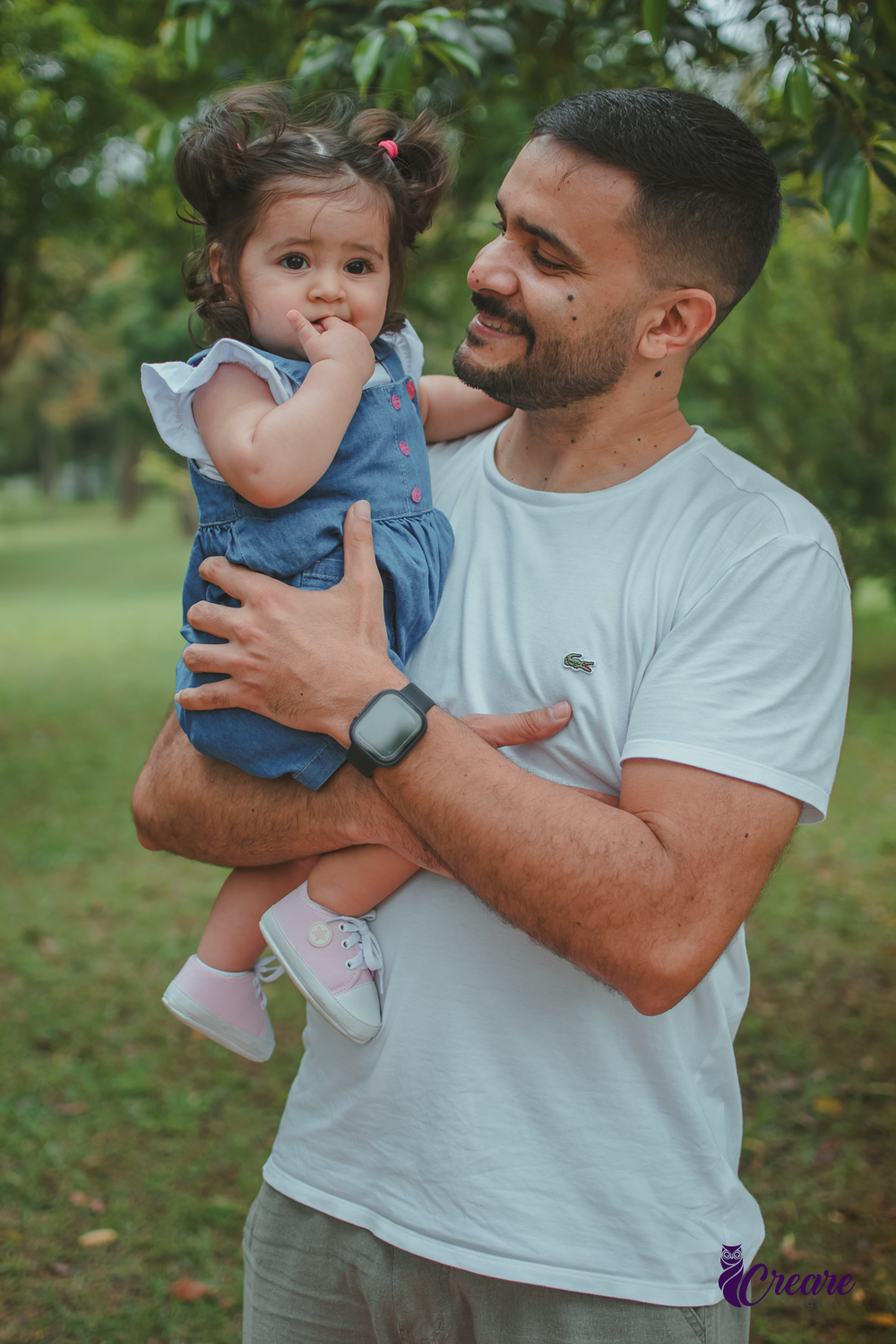 Um homem com uma bebê no colo, durante festa de aniversário de 1 ano no Parque Central de Santo André.