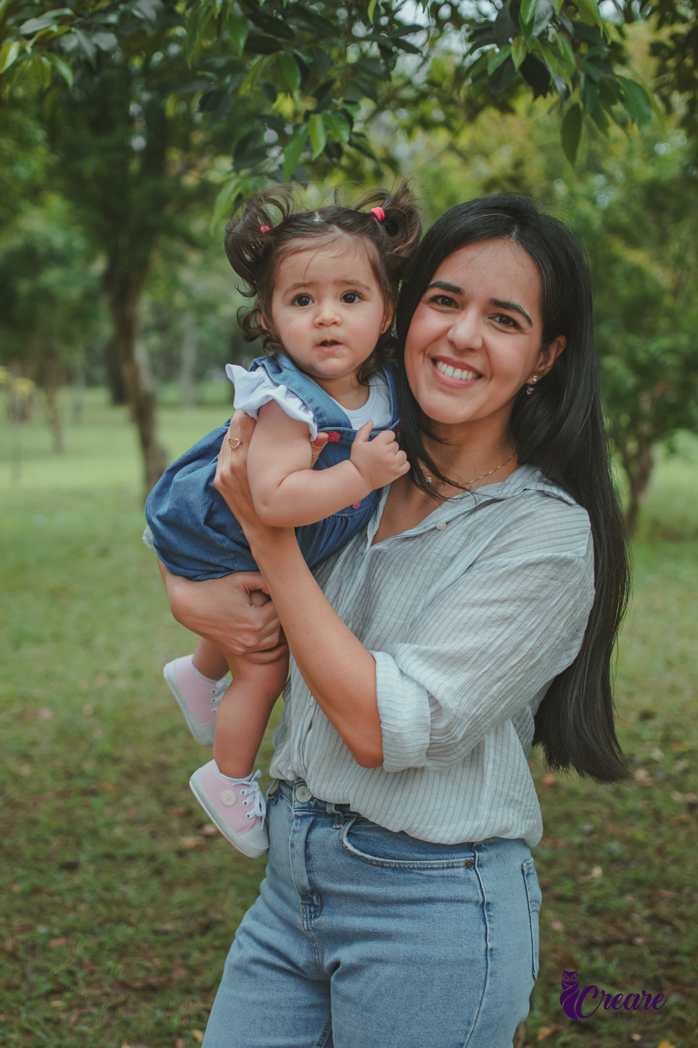 Uma mulher com uma bebê no colo, durante festa de aniversário de 1 ano no Parque Central de Santo André.