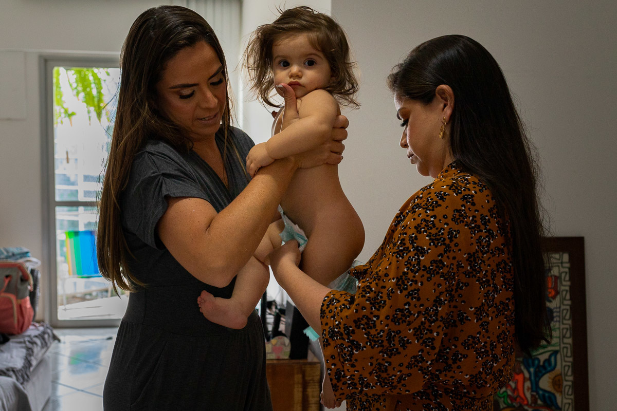 Aniversário Infantil, Rio de Janeiro, Fotografia documental de família, mãe e madrinha retirando a fralda para o banho