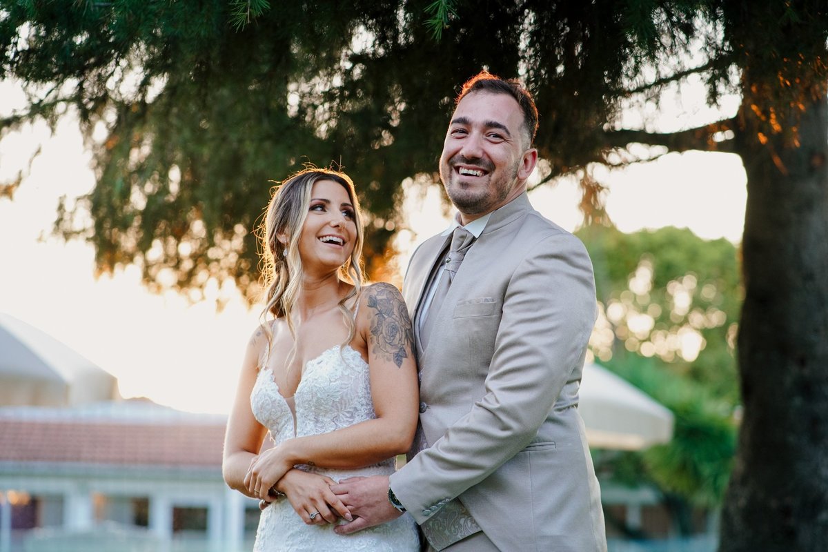 sessão de noivos abraçados a sorrir ao pôr-do-sol