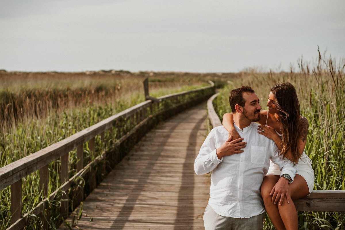 sessão de solteiros, casal abraçado sentado nos passadiços em Esmoriz