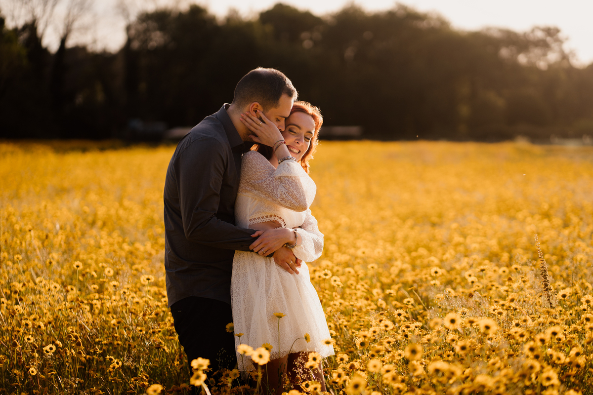foto solteiros, foto engagement, noivos, casal abraçado em campo de flores, campo de malmequeres, casal num campo de flores amarelas, casamento, fotos noivado,