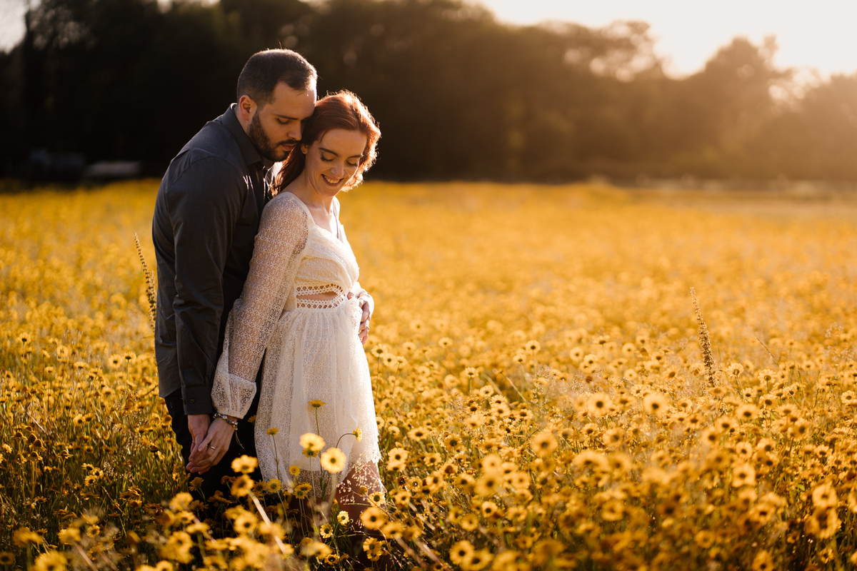 foto solteiros, foto engagement, noivos, casal abraçado em campo de flores, campo de malmequeres, casal num campo de flores amarelas, casamento, fotos noivado,