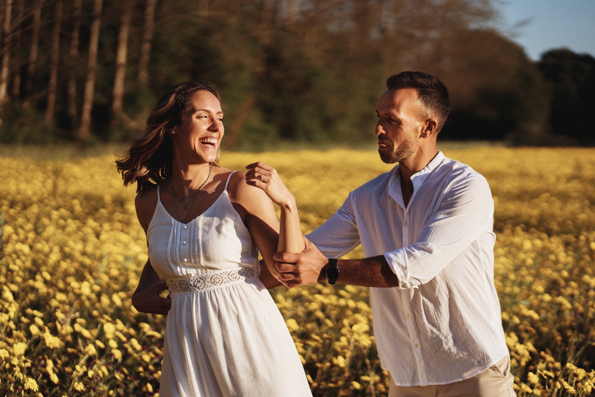 Joana e Tiago, noivos agarrados ao pôr-do-sol num campo de flores amarelas, noivos nos malmequeres, noivos nos girassóis 