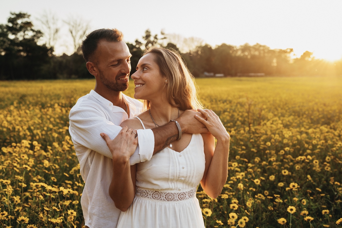 Joana e Tiago, noivos agarrados ao pôr-do-sol num campo de flores amarelas, noivos nos malmequeres, noivos nos girassóis 