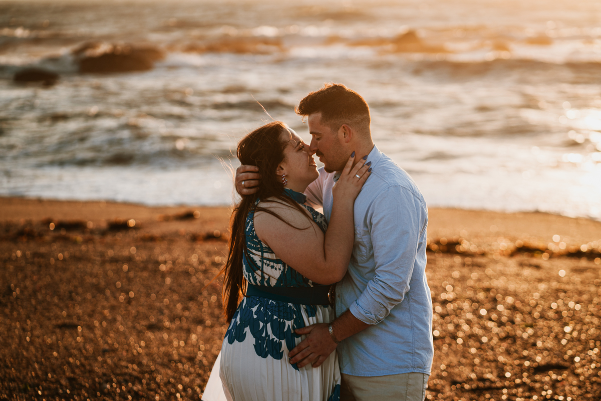 Érica e João, miramar, senhor da pedra, engagement, igreja do senhor da pedra, fotografia na praia, fotografia ao põr-do-sol, sessão fotográfica, casal abraçado ao pôr-do-sol, noiva com flor vermelha na orelha, noivos com gargalhadas, noivos descontraídos