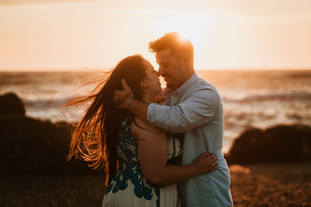 Érica e João, miramar, senhor da pedra, engagement, igreja do senhor da pedra, fotografia na praia, fotografia ao põr-do-sol, sessão fotográfica, casal abraçado ao pôr-do-sol, noiva com flor vermelha na orelha, noivos com gargalhadas, noivos descontraídos
