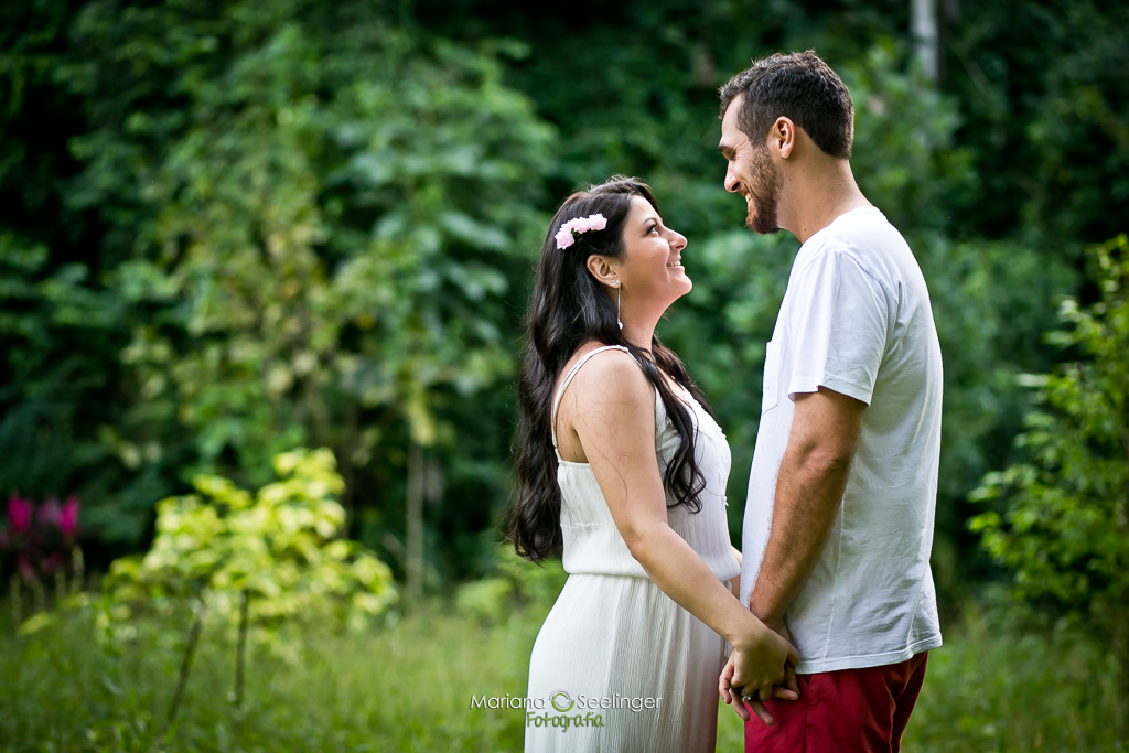 Ensaio romântico de casal realizado em área verde de rio bonito rj, noiva usando vestido claro simples, flores no cabelo emclique de MAriana Seelinger Fotógrafa de Casamentos