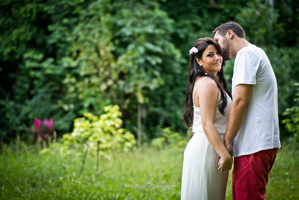 Fotografia romântica de casal demãos dadas em fundo verde, Rio Bonito RJ, em fotografia de Mariana Seelinger Fotógrafa de Casamentos e Famílias
