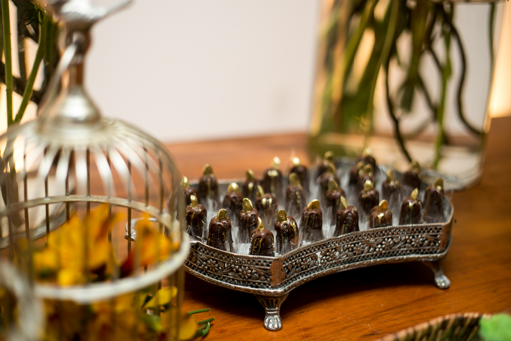 Doces de casamentos dentro de bandeja cinza em cima de mesa de madeira rústica em fotografia de Mariana Seelinger Fotógrafa de Casamentos em Niterói e RJ