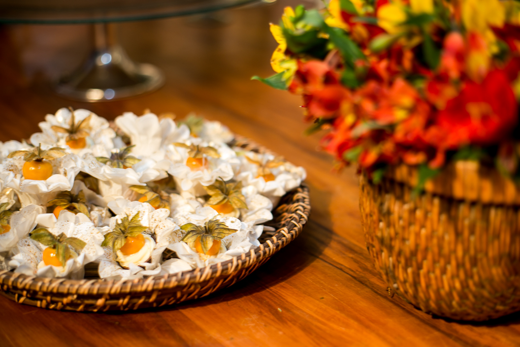 Doces de casamentos com forminhas de flores brancas em cima de mesa de madeira rústica em fotografia de Mariana Seelinger Fotógrafa de Casamentos em Niterói e RJ