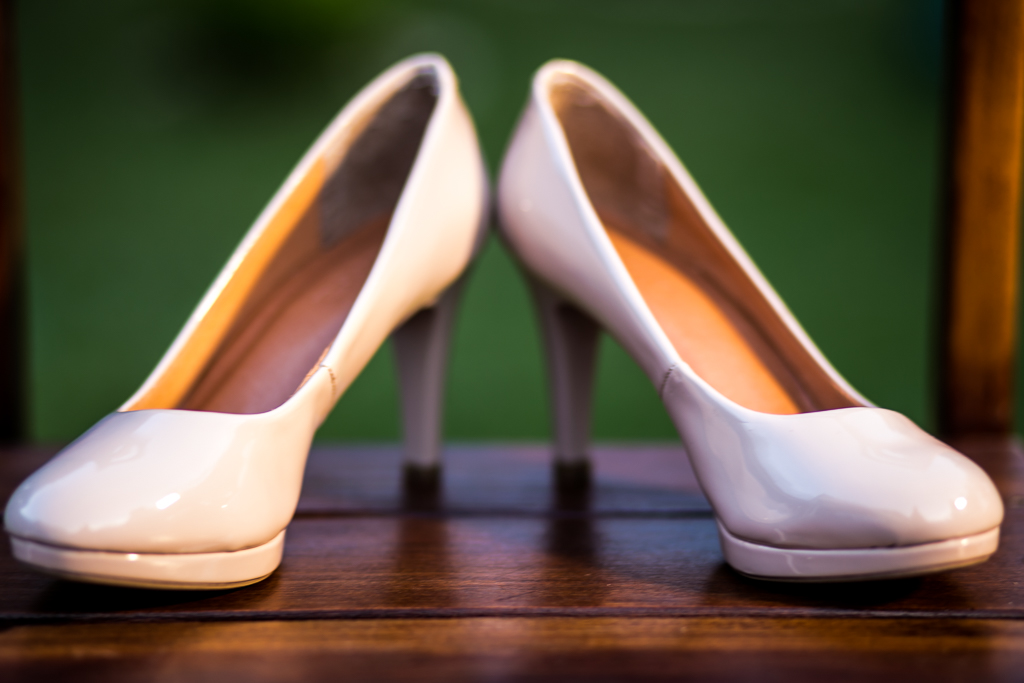 Sapato rosa da noiva apoiado em cadeira de madeira em fotografia de Mariana Seelinger Fotógrafa de Casamentos em Niterói e RJ