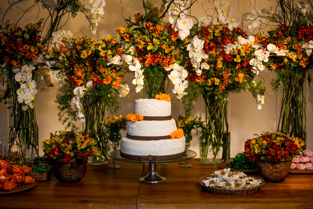 Bolo de casamento com três andares  com faixas marrons e flores laranjas em fotografia de Mariana Seelinger Fotógrafa de Casamentos em Niterói e RJ