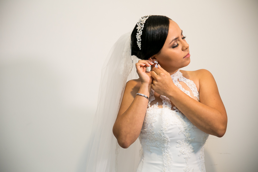 Foto da noiva colocando o brinco durante o making of em fotografia de Mariana Seelinger Fotógrafa de Casamentos em Niterói e RJ