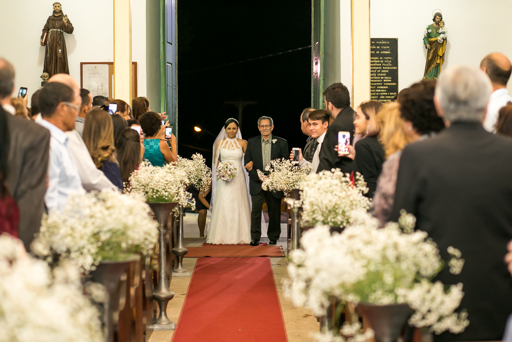 Entrada da noiva na igreja acompanhada de seu pai em fotografia de Mariana Seelinger Fotógrafa de Casamentos em Niterói e RJ