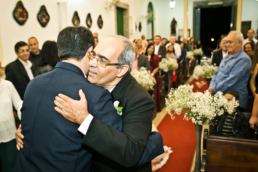 Pai da noiva cumprimentando o noivo depois de ter levado a noiva até o altar em fotografia de Mariana Seelinger Fotógrafa de Casamentos em Niterói e RJ