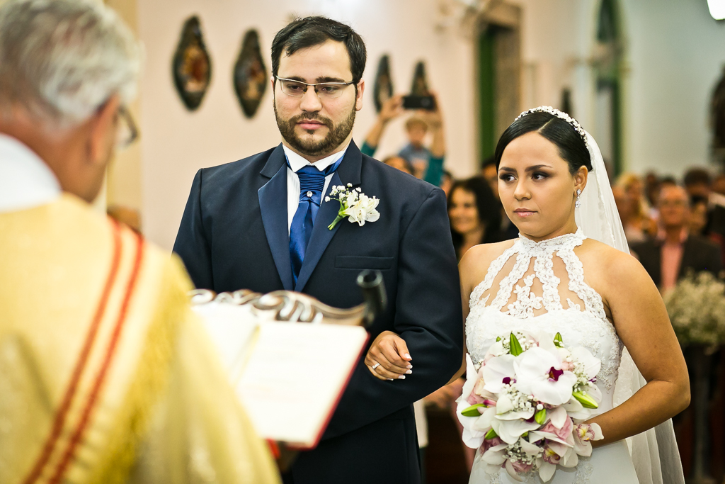 Casal de noivos escutando o celebrante de casamentos em fotografia de Mariana Seelinger Fotógrafa de Casamentos em Niterói e RJ