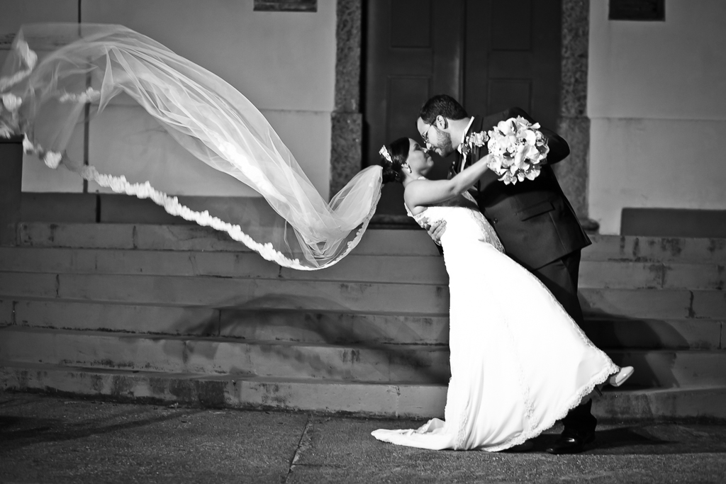 Foto dos noivos com véu voando na Igreja de Itaipu Niteroi em registro de Mariana Seelinger Fotógrafa de Casamentos em Niterói e RJ