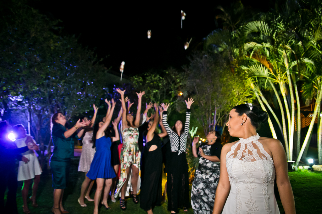 Noiva jogando o bouquet de santo antonio em fotografia de Mariana Seelinger Fotógrafa de Casamentos em Niterói e RJ