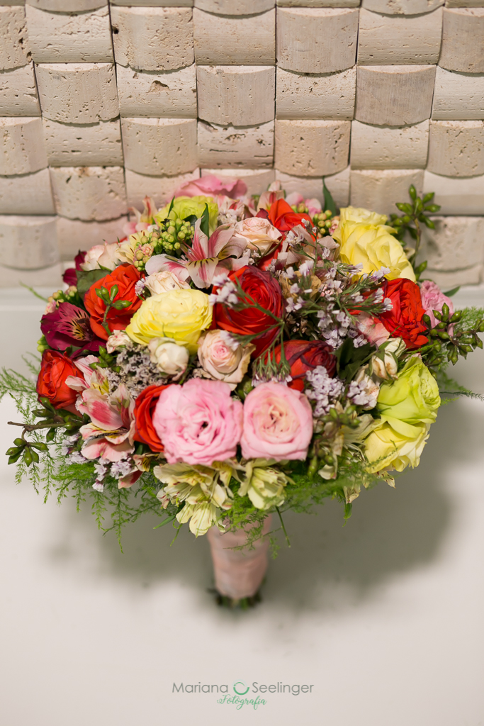 Bouquet colorido da noiva em fundo de pedras claras em fotografia de Mariana Seelinger fotógrafa de casamentos e famílias em Niterói RJ