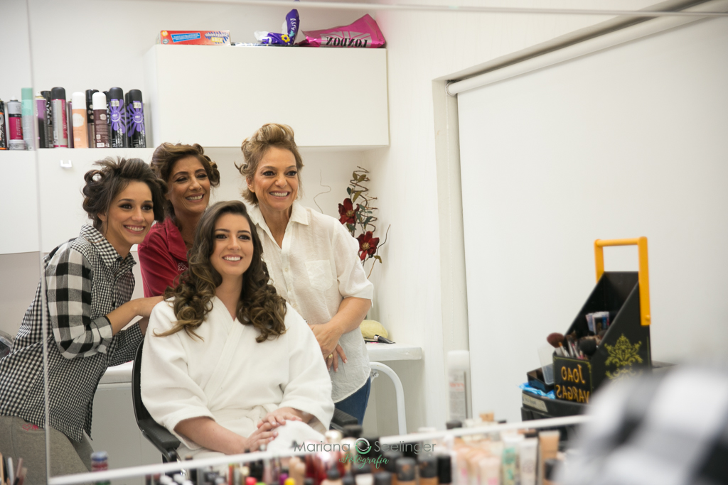 Foto da noiva com mãe e sogra durante o making of  em fotografia de Mariana Seelinger fotógrafa de casamentos e famílias em Niterói RJ