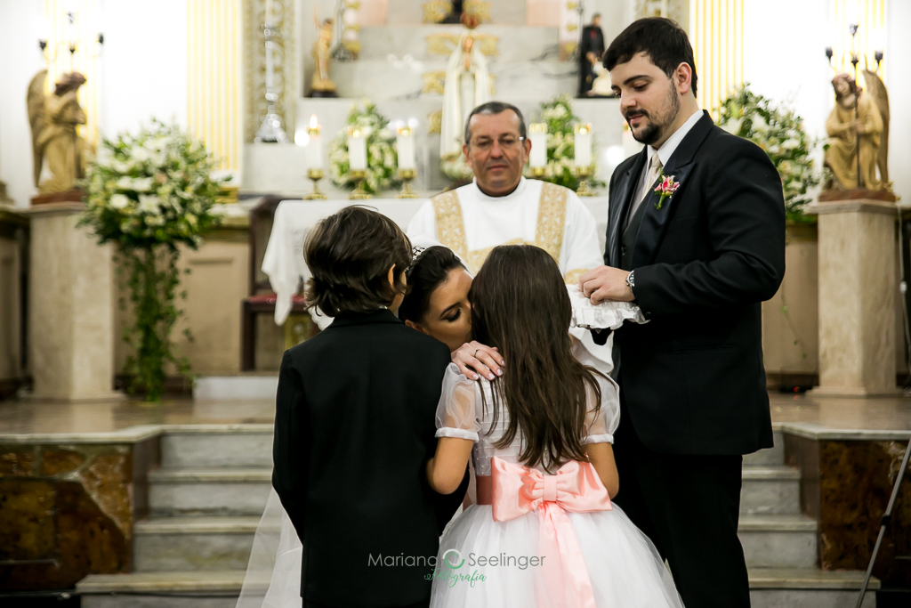 Noivos recebendo as alianças no altar pelo pajem e pela daminha em fotografia de Mariana Seelinger Fotógrafa de Casamentos em Niterói e RJ